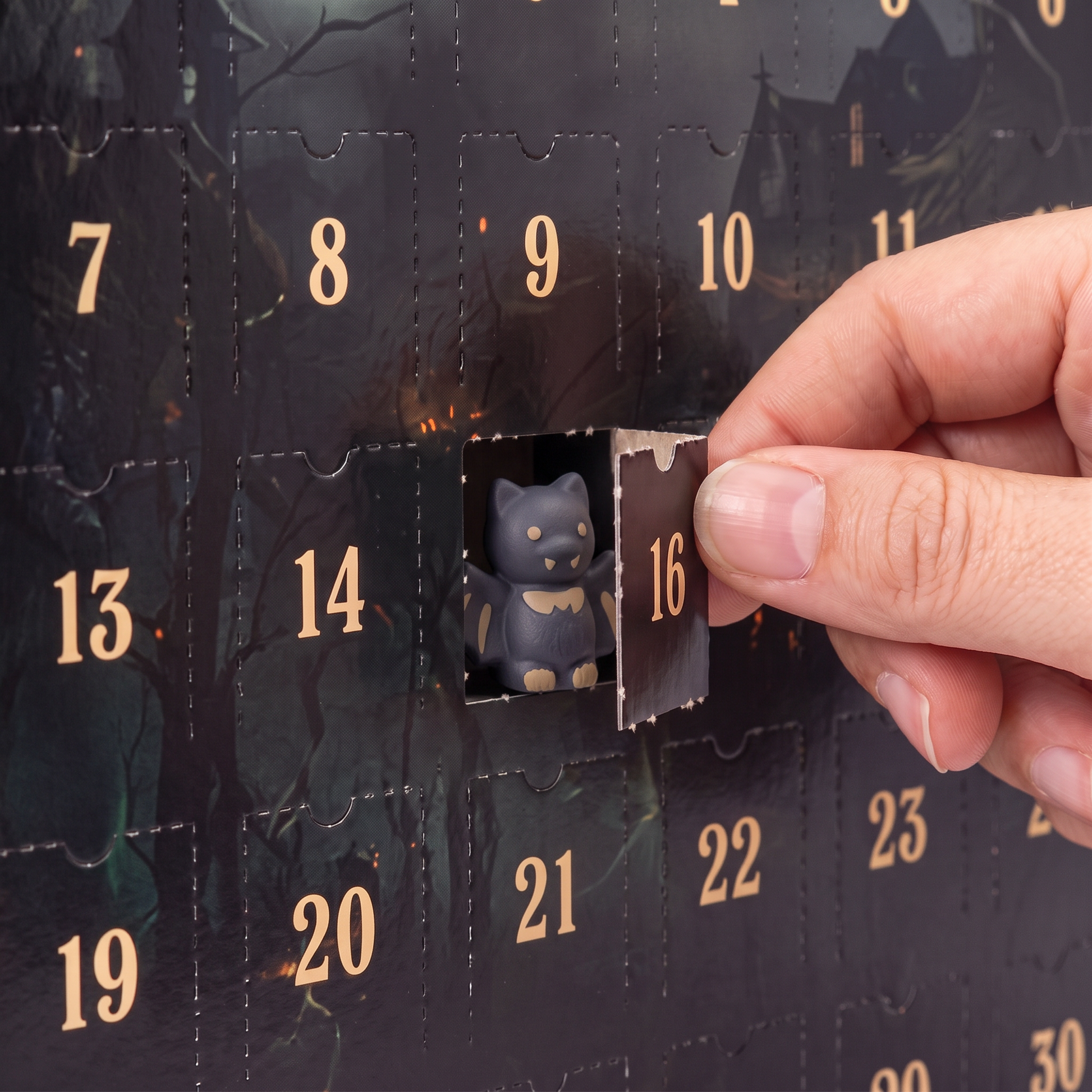 Close-up of door 15 opened on its perforated hinge with a collectible figure waiting inside